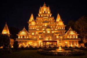 a large building is lit up at night at H0TEL PARBU KIRPAA Near Premanand Ji Maharaj Mandir Vrindavan in Chhatikara