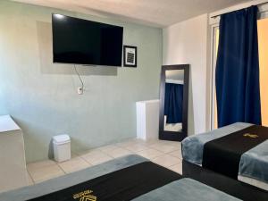 a room with two beds and a flat screen tv at 4 VENATOR House Boutique in León