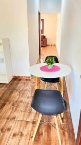 a white table with two chairs and a plant on it at Casa da Ana in Tutóia +5 photos