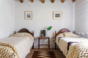 a bedroom with two beds and a side table at El Caserío Jujuy in Volcán