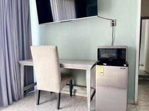 a white desk with a chair and a microwave at 5 VENATOR House Boutique in León