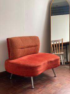 a red chair sitting in front of a mirror at PAMA'Pranakorn in Bangkok