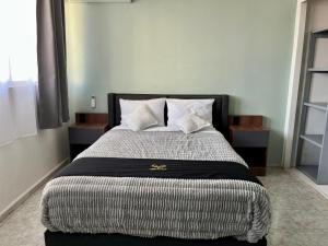 a bedroom with a large bed with white pillows at 6 VENATOR House Boutique in León