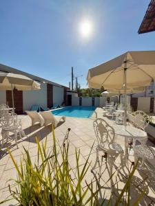 a patio with tables and chairs and a pool at Studio VI até 7 pessoas em Juquehy in São Sebastião
