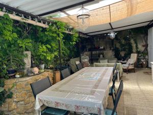 a patio with a table and chairs and plants at Chambres d'Hôtes et Gîtes Le Mas Mellou in Orange