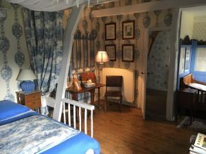 a bedroom with a bed and a desk and a table at Le Prieuré Boutefol in Surville