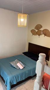 a bedroom with a bed and a chair with umbrellas on the wall at Pousada Suítes Sete Mares in Guarujá