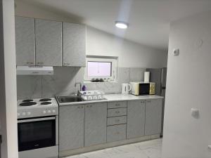 a kitchen with a sink and a stove top oven at Apartman Rose in Čapljina