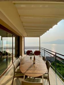 a wooden table on a balcony with a view of the water at casa prima vista in Torri del Benaco