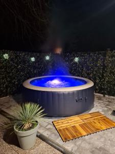 a large hot tub with blue water in it at Maisonnette Rétro Loc in Amfréville