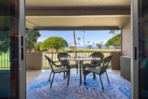 a table and chairs on a patio with a view at Maui Eldorado H202 in Kaanapali