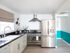 a kitchen with a stainless steel refrigerator and a sink at Cambria Beach Lodge in Cambria