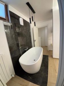 a white bath tub in a bathroom with a black wall at Elegante suite con box privato e vista in Aprica +34 photos