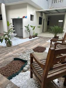 a patio with a wooden bench and potted plants at Hotel Pousada Romanos in Aparecida