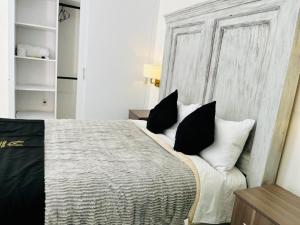 a bedroom with a bed with black and white pillows at 12 VENATOR House Boutique in León +7 photos