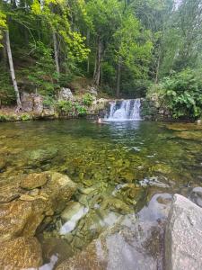 a waterfall in the middle of a river with rocks at Dziedziniec Karkonoszy in Podgórzyn