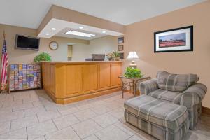 a lobby with a reception desk and two chairs at North Platte Inn and Suites in North Platte