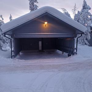a building with a light on it in the snow at Pääsiäiskuru 3 in Kakslauttanen
