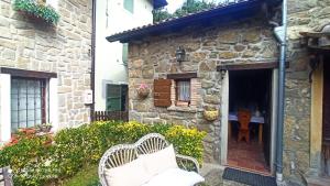 a stone house with a bench in front of a door at Il BORGO DEL VENTASSO in Busana