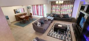 a living room with a couch and a tv at El Ain El Sokhna-Villa at Piacera Resort Seaview in Ain Sokhna