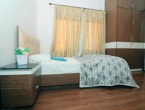 a bedroom with a bed with a dresser and a window at Pepa's villa and homestay in Khadkagaon