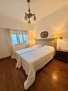 a bedroom with two beds and a chandelier at Casa LUHA in San Antonio de Areco +36 photos
