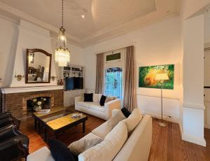 a living room with a white couch and a fireplace at Casa LUHA in San Antonio de Areco