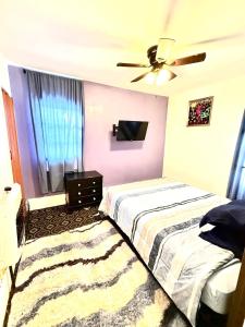 a bedroom with two beds and a ceiling fan at A cozy home with fire place in Detroit