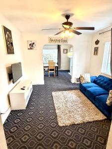 a living room with a blue couch and a tv at A cozy home with fire place in Detroit