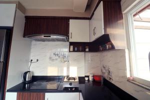 a small kitchen with a stove and a window at Pepa's villa and homestay in Khadkagaon +9 photos
