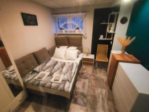 a small bedroom with a bed and a couch at Apart Radzice in Radzice Małe