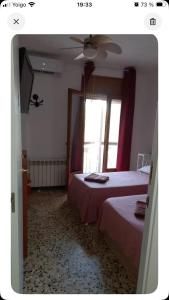 a bedroom with two beds and a window at Habitaciones Yanet in La Granada