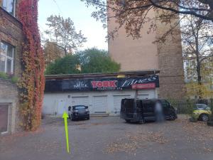 a garage with two cars parked in a parking lot at Ofiss 24 in Riga