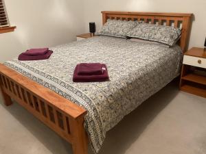 a bedroom with a large bed with a purple bag on it at Taighali Apartment in Aultbea