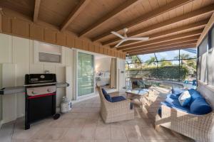 a screened in porch with a couch and a stove at Tahitian Waters in Sanibel
