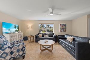 a living room with two couches and a table at Tahitian Waters in Sanibel