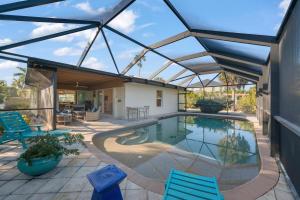 a swimming pool in a conservatory with blue chairs at Tahitian Waters in Sanibel