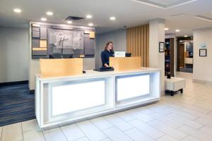 a woman standing at a counter in a lobby at Holiday Inn Express Hotel & Suites-Hinton by IHG in Hinton +25 photos