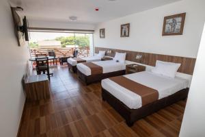 a hotel room with two beds and a table at Centro Recreacional Simbal in Trujillo