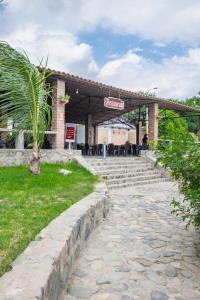 a building with a palm tree in front of it at Centro Recreacional Simbal in Trujillo
