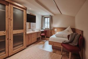 a bedroom with a bed and a desk in it at Hotel Austria Lech in Lech am Arlberg