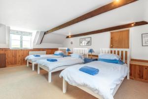 a group of four beds in a room at Nelson Lodge in Burnham Market