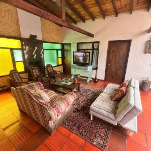 a living room with two couches and a tv at Hospedaje La Casona in Tabio