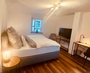 a bedroom with a bed and a television in it at Ferienhaus Griede mit 3 Schlafzimmern in Mörsdorf