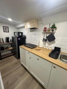 a kitchen with white cabinets and a black refrigerator at Cozy Basement Studio with Private Bathroom and Kitchen in Vaughan