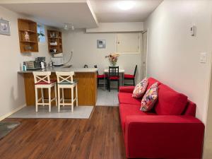a living room with a red couch and a kitchen at Lovely suite in Burnaby +6 photos