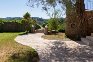 a stone walkway in a yard with a tree at Villa Odyssey Verde in Dassia