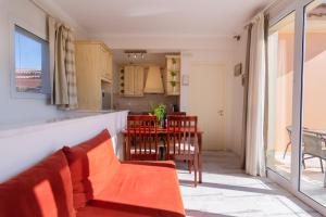 a living room with a couch and a table with chairs at Villa Odyssey Verde in Dassia