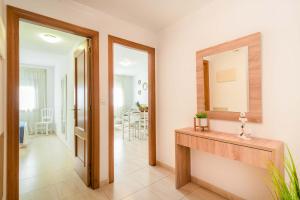 a bathroom with a sink and a mirror and a hallway at Apartamentos Punta Lucero en Portonovo in Portonovo +49 photos