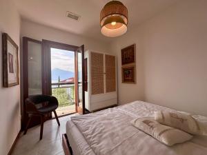 a bedroom with a bed and a chair and a window at casa prima vista in Torri del Benaco
